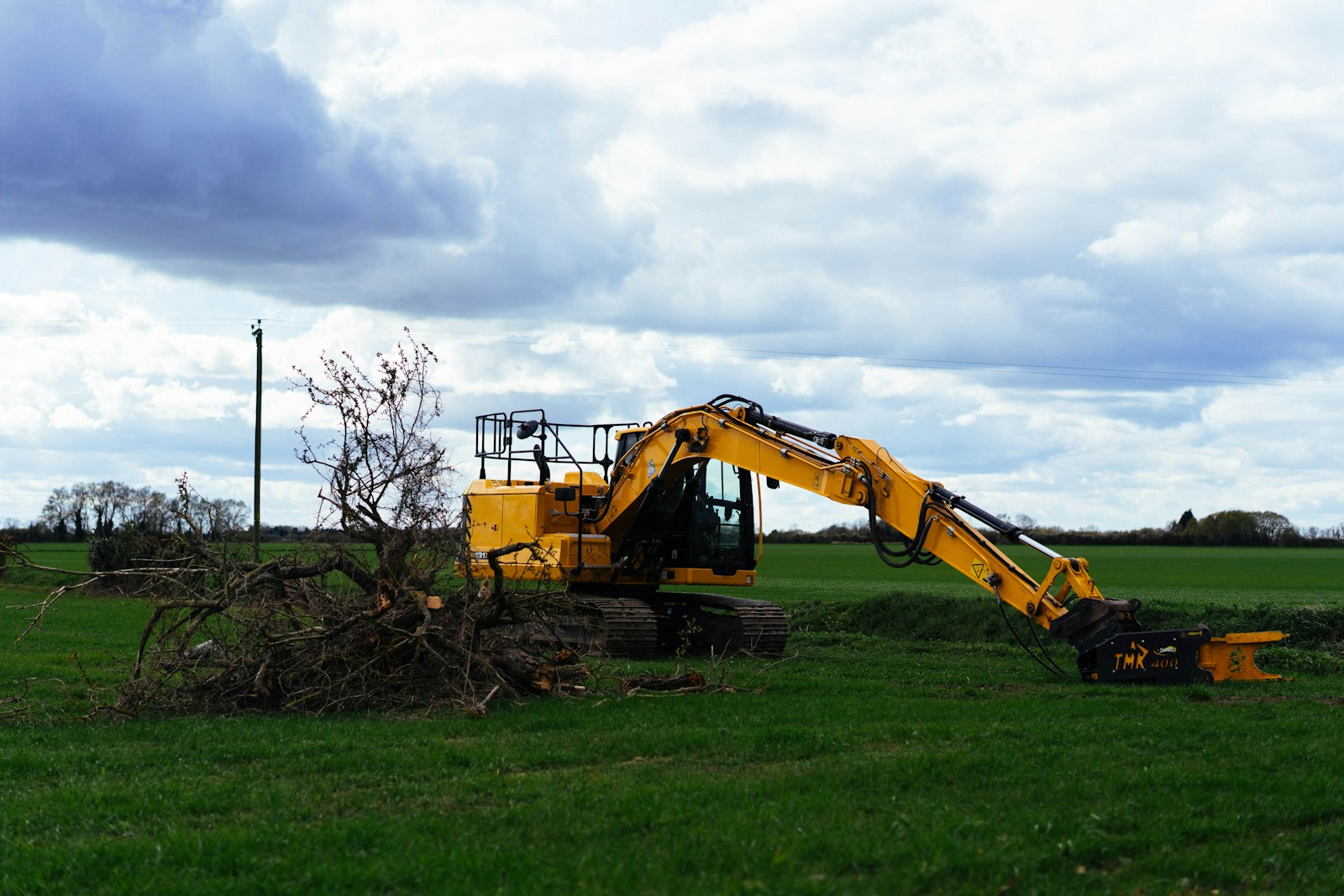 Excavator clearing and pulling trees on a land-clearing job